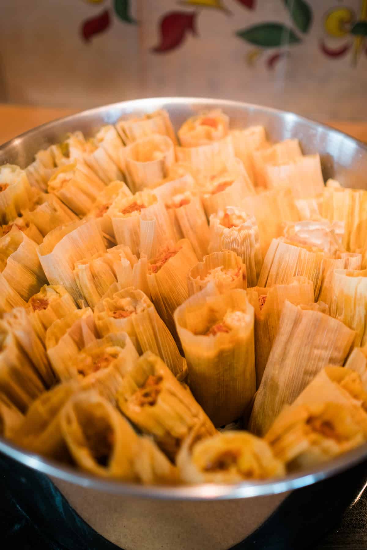 close up shot of tamales steaming in a tamalera (tamale steamer pot). 
