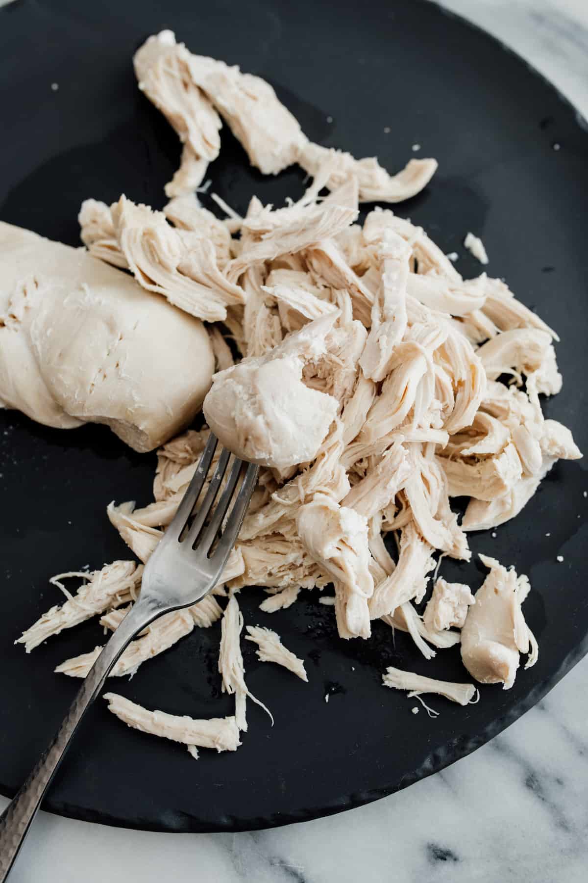 shredding chicken breasts with a fork.