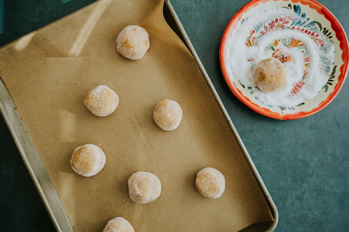 rolling peanut butter cookie dough balls in sugar.