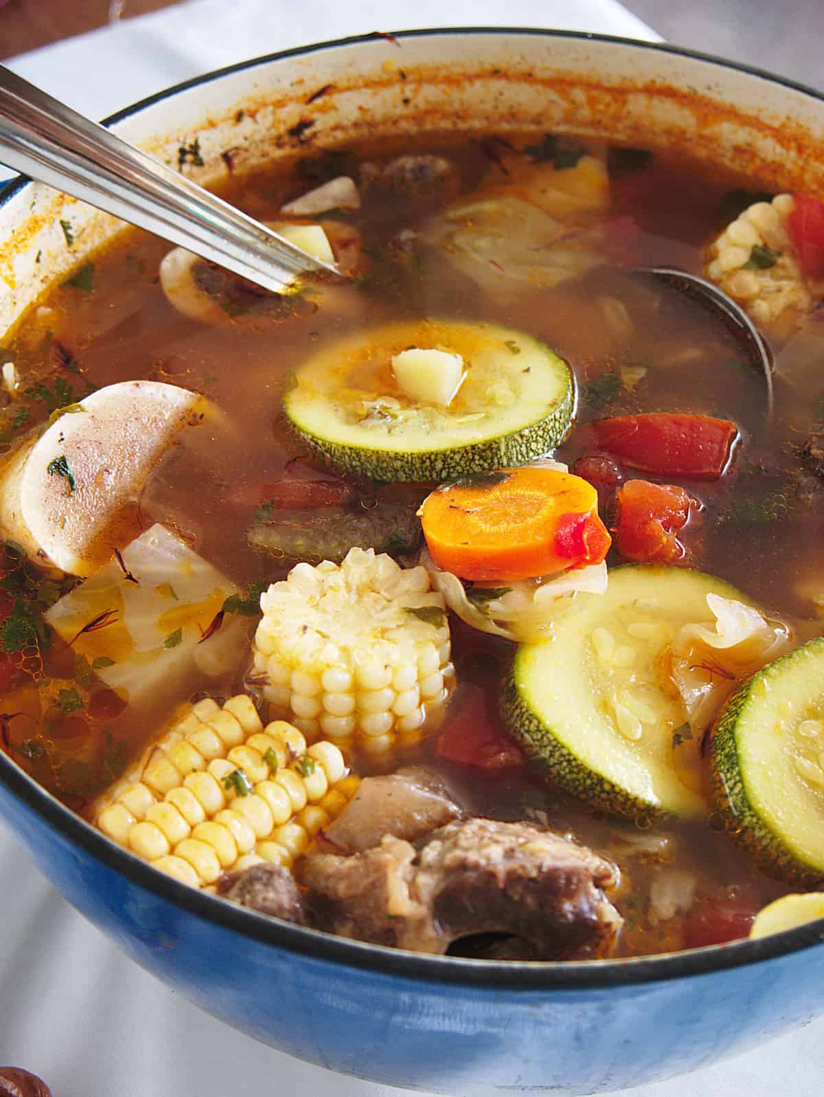 pot of caldo de res with corn, zucchini, beef and bones