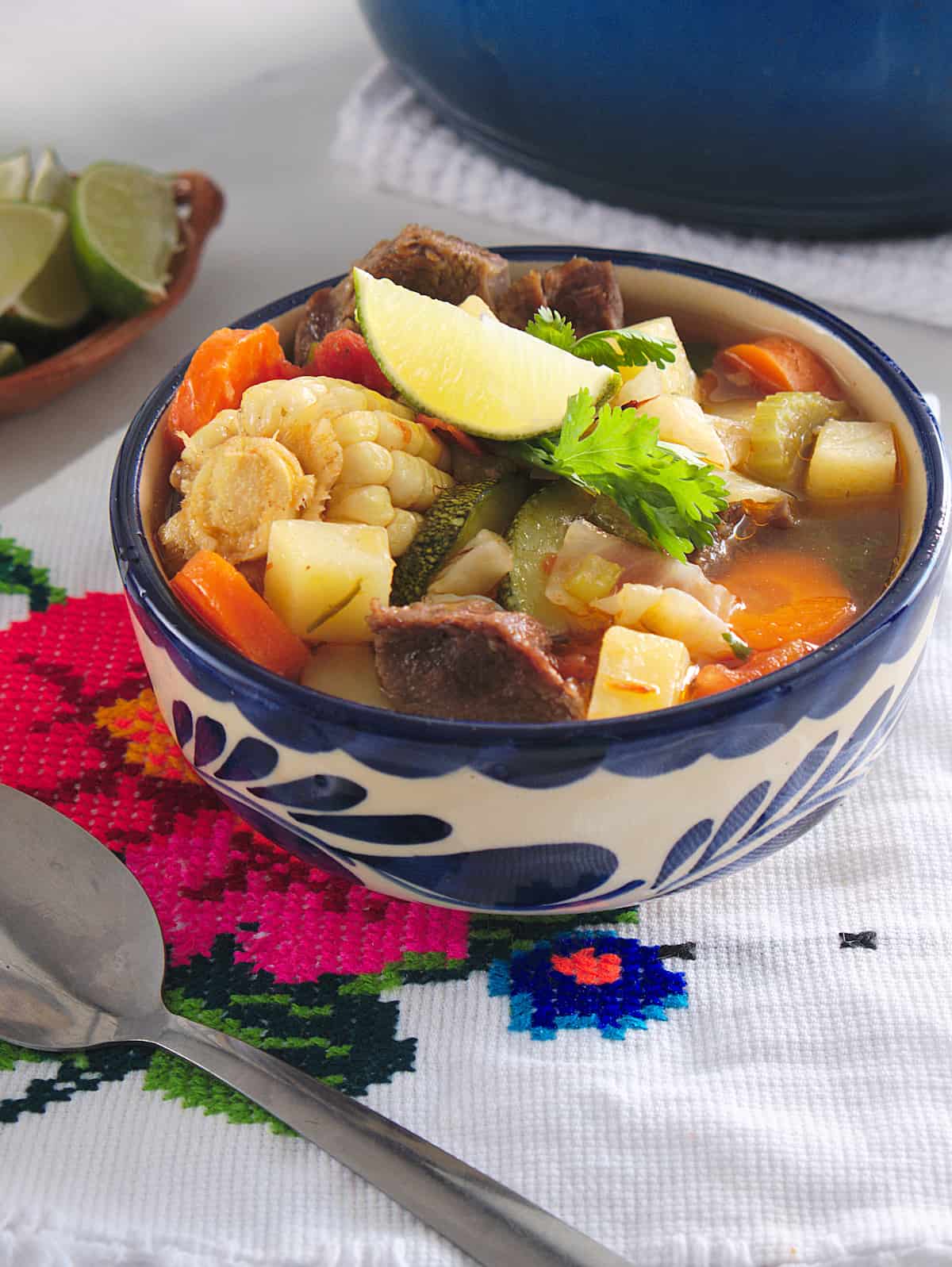 caldo de res beef soup in a Mexican blue and white bowl.