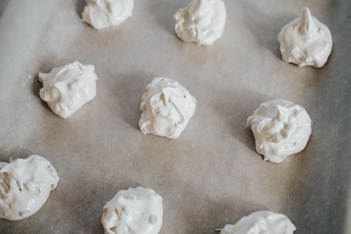 unbaked chocolate chip meringues on a parchment lined baking sheet. 